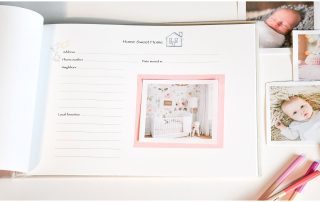 Pink cloth cover baby memory book with open page and photos