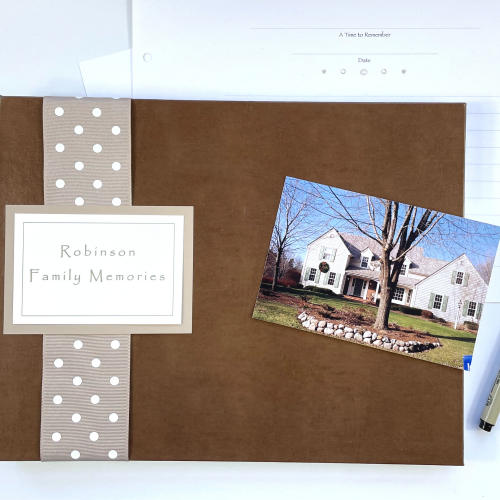 Brown leather favorite memories book shown with blank pages and photo of a house