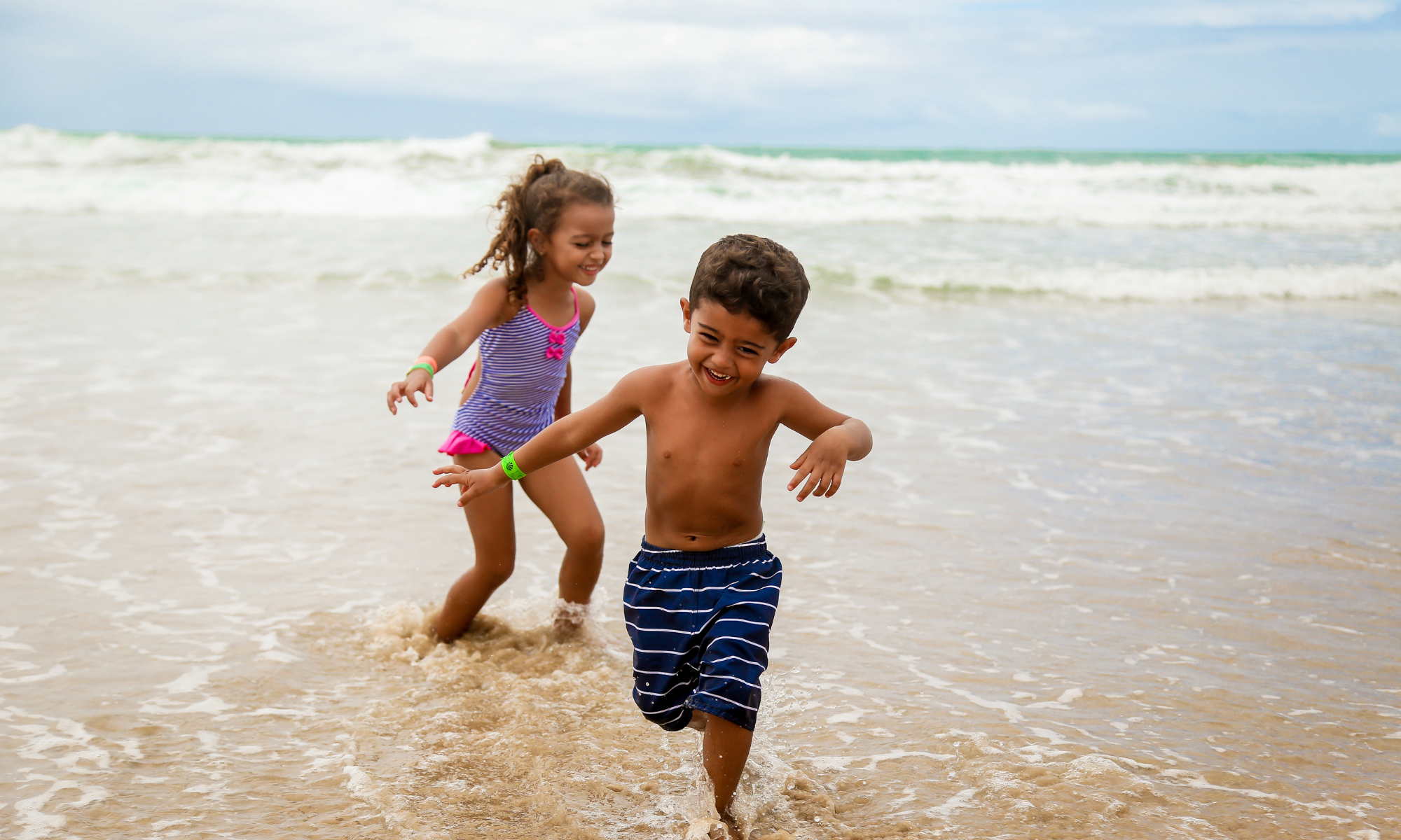 capturing your kid's summer activities photo of two kids running on the beach