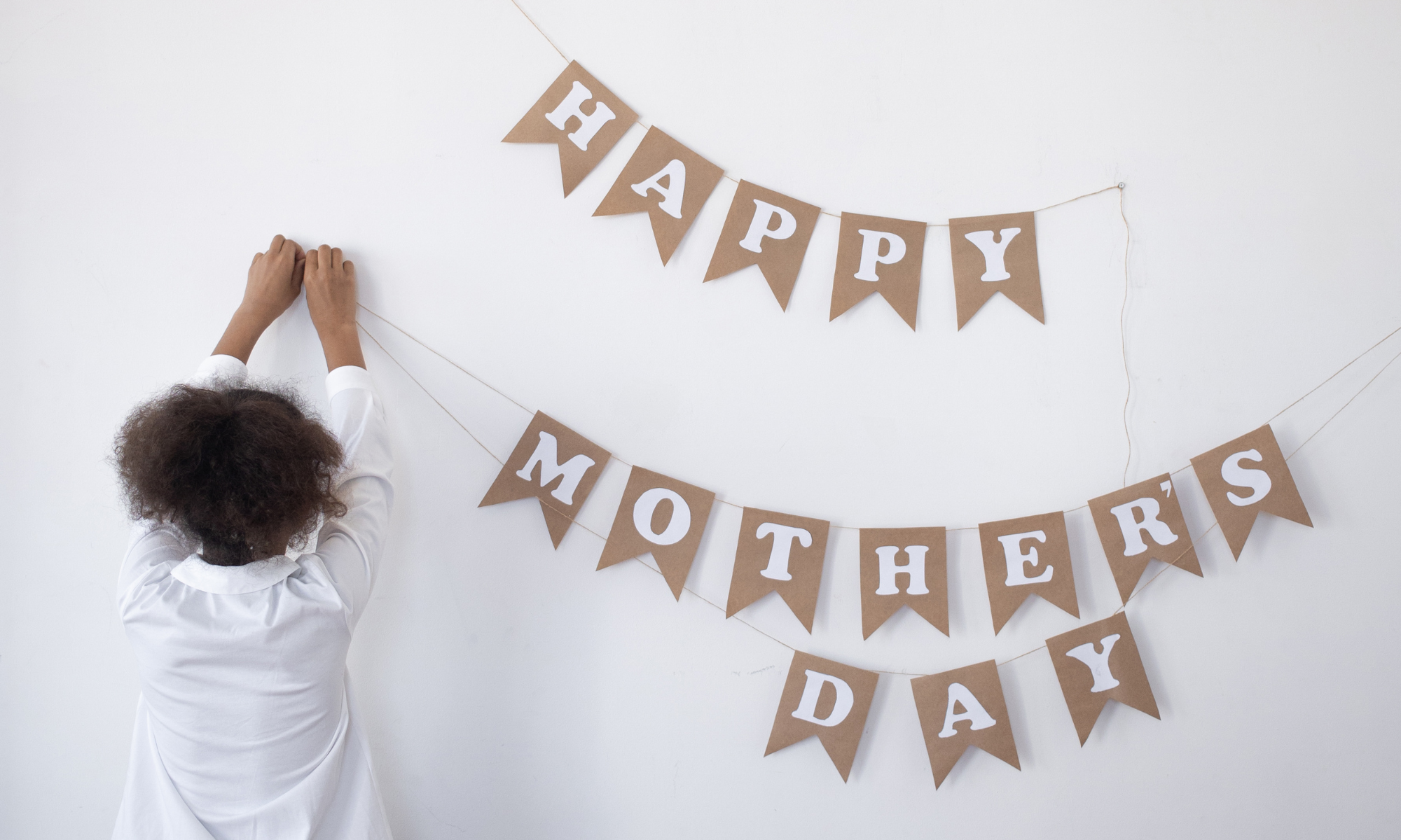 child hanging a mother's day banner